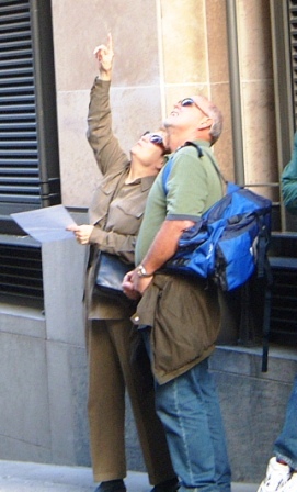 2 people pointing up at a clue.