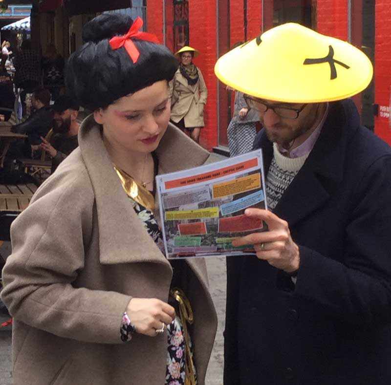 Two people read a riddle on their Chinatown treasure hunt.