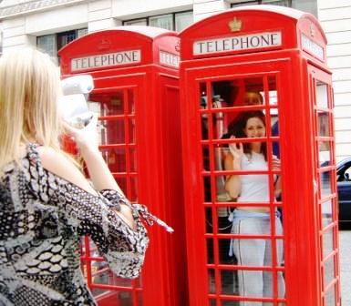 A girl in a phone box looking for a treasure hunt clue in Westminster.