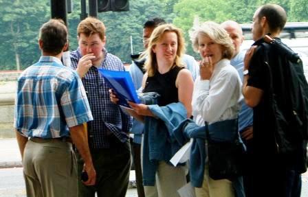 Group pondering a treasure hunt clue by the River Thames.