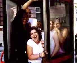 Group cramming in to a phone box.