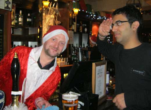 A treasure hunt participant salutes a barman dressed as Santa.