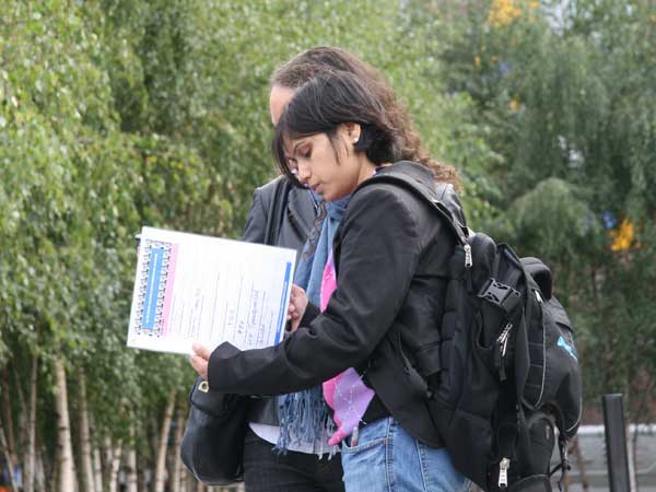 A man and a woman reading one of their challennges on the Chiswick Treasure Hunt.