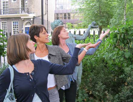 Three women doing a pose as a tree.