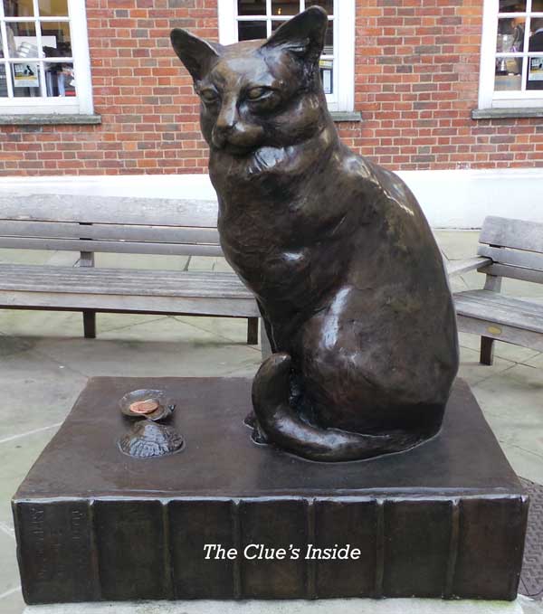 A statuette of Hodge the cat sitting on top of a copy of Dr Johnson's dictionary.