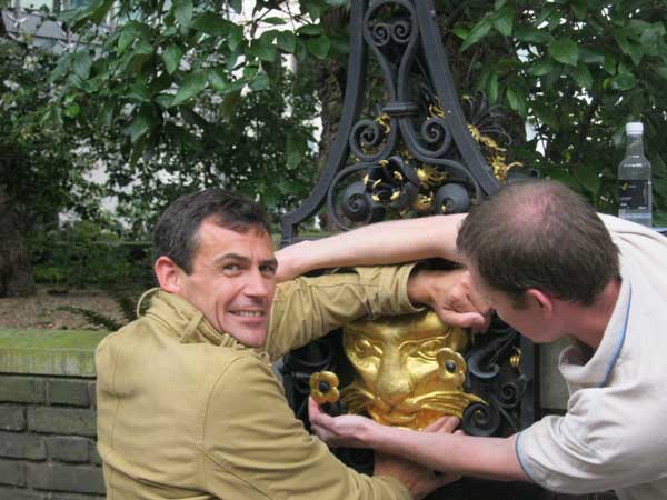Two men studying a golden cat's head for one of their St Paul's clues.