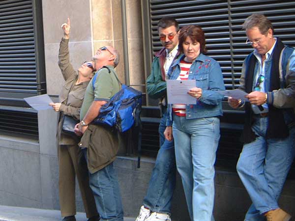 Team members reading a clue and pointing upwards on the Canary Wharf Treasure Hunt.